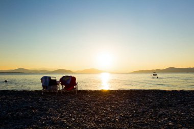 Uzun kıyı şeridi, yanındaki şezlong yanındaki iki oturma yeri olmak