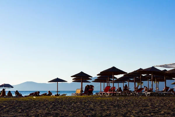 Osłona przeciwsłoneczna z ludźmi przez piaszczystej plaży — Zdjęcie stockowe