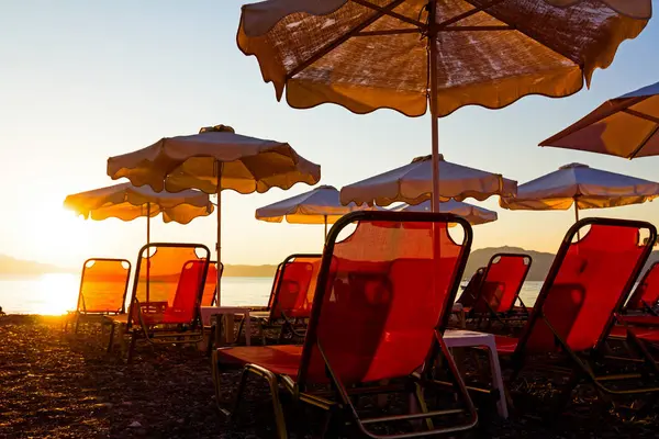 Widok sylwetka słońce publicznej plaży z parasolami, leżakami — Zdjęcie stockowe