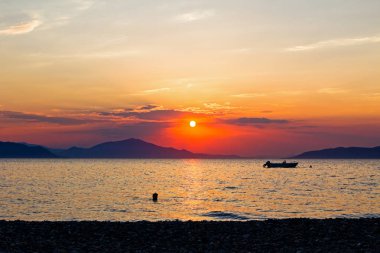 Denize akşam zamanında güzel günbatımı manzaralı görünüm
