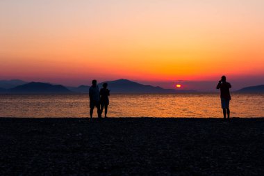 Günbatımı çift, insanlar plajda ile kontrast atış