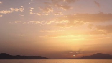 deniz üzerinde bulutlu gün batımı