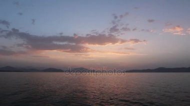 deniz üzerinde bulutlu gün batımı