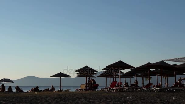 Ombre solaire avec des gens près de la plage de sable — Video