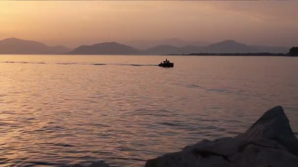 Barco de pesca está em transporte passando sobre o mar ao pôr do sol — Vídeo de Stock