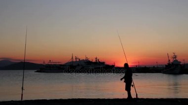 Üst düzey bir adamın iskelede Balık tutma günbatımında kontrast atış