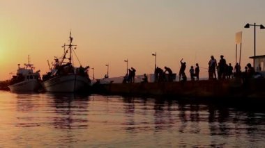 Gün batımında iskelede Balık tutma bir insan kontrast atış