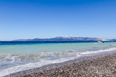 Deniz köpüklü dalgalar kırılıyor bir plajda çakıl karşı sahil