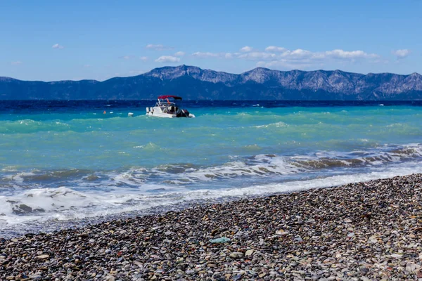 Küçük iskele tekne köpüklü dalgalar ile plajına yakın bağlantılı