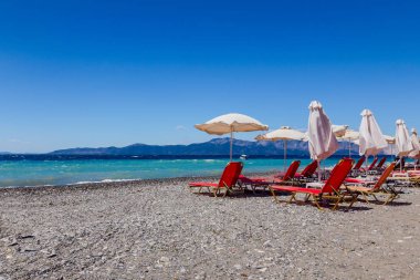 Şemsiye şezlong ile yanındaki sahil şeridi yerleştirilir 