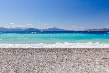 Deniz köpüklü dalgalar kırılıyor bir plajda çakıl karşı sahil