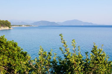 Yeşil bitki örtüsü ve mavi deniz suyu koy görüntüleyin 