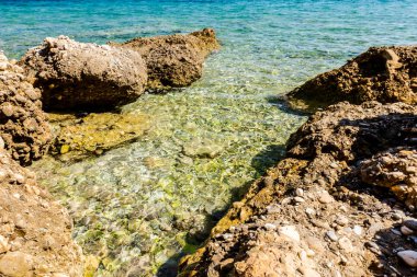 Su erozyonu tarafından oluşturulan sığ turkuaz Denizi kayalık sahil