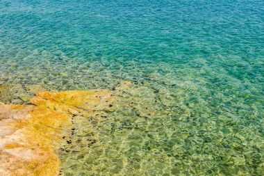 Su erozyonu tarafından oluşturulan sığ turkuaz Denizi kayalık sahil