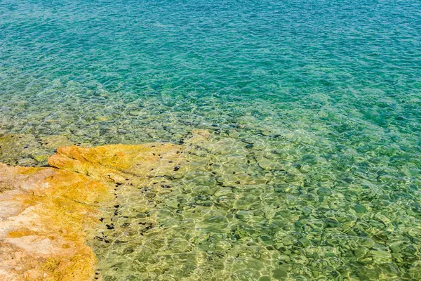 Su erozyonu tarafından oluşturulan sığ turkuaz Denizi kayalık sahil
