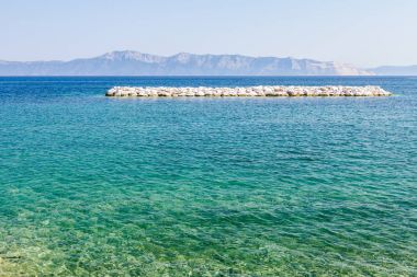 Deniz kıyısı boyunca büyük yapay resif olarak taş yığını yığılmış 