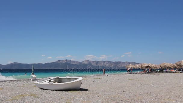 Witte kleine roeiboot boot droog aangemeerd op het strand — Stockvideo