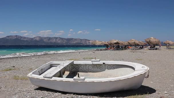 Barco a remos branco pequeno barco seco ancorado na praia — Vídeo de Stock