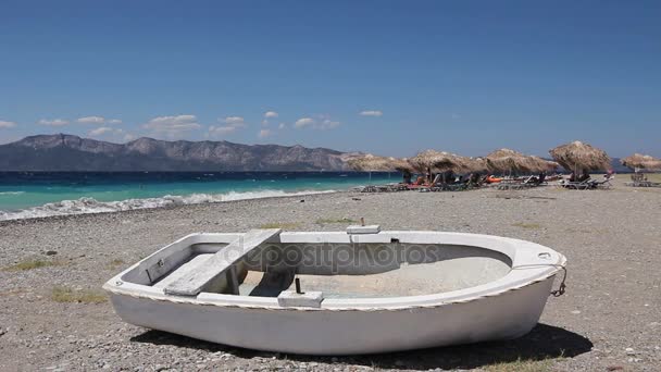 White small rowboat boat dry docked on the beach — Stock Video