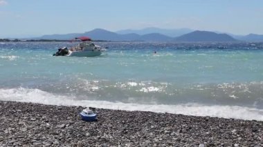 Küçük iskele tekne köpüklü dalgalar ile plajına yakın bağlantılı