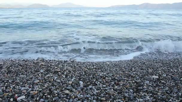 La salida del sol, la mañana sobre el mar con las ondas espumosas contra los guijarros en la playa, la costa — Vídeos de Stock