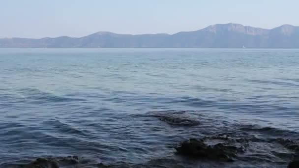 Скала торчит над мелководьем, над уровнем моря — стоковое видео