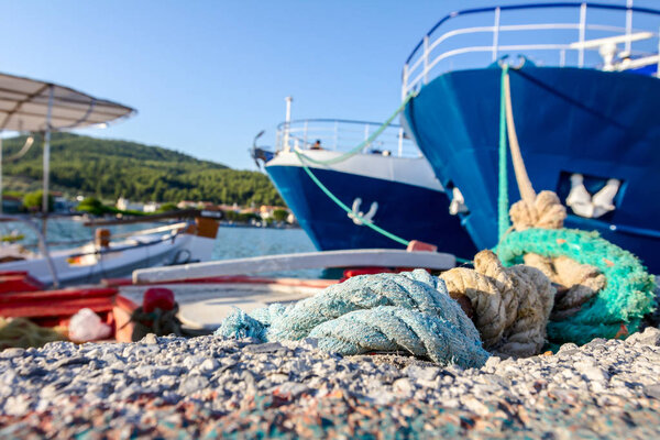 Two big fishing boats are tied up with rope for the dock, marina