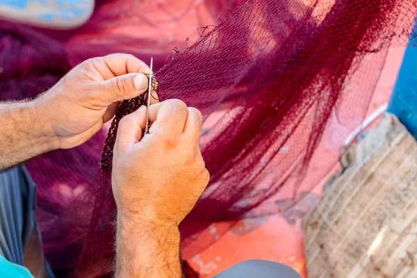 Pescador está consertando a rede de peixes — Fotografia de Stock
