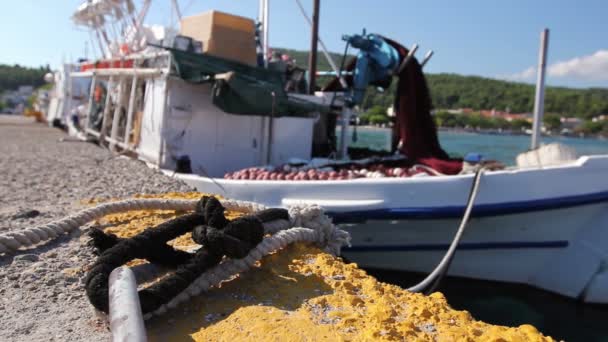 Barco de pesca blanco está atado con cuerda para el anillo de acero en el muelle, muelle — Vídeos de Stock