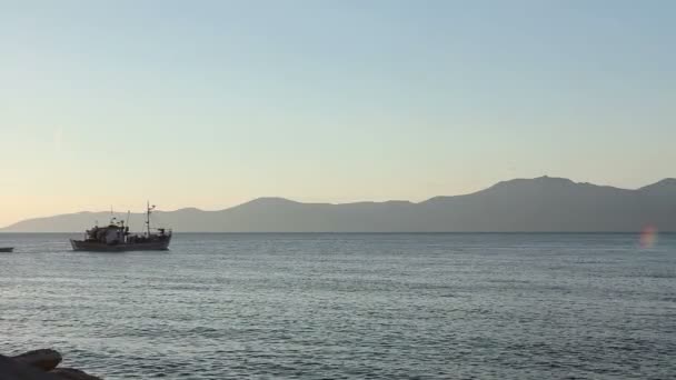 Rybářská loď je v dopravě procházející přes moře při západu slunce — Stock video