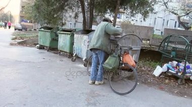 Adam bisikleti ile kentsel povertyhomeless erkekte çöp inceler.