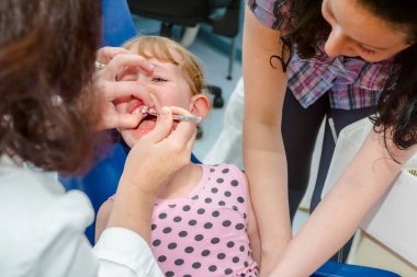 Açık ağız, diş hekimi, diş ile korkmuş tatlı küçük kız 