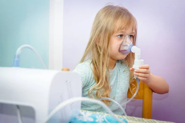 Porträtt av söt liten flicka med hjälp av en inhalator — Stockfoto