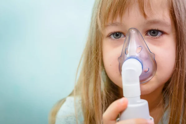 Porträtt av söt liten flicka med hjälp av en inhalator — Stockfoto