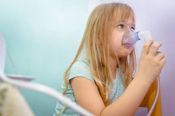 Porträtt av söt liten flicka med hjälp av en inhalator — Stockfoto