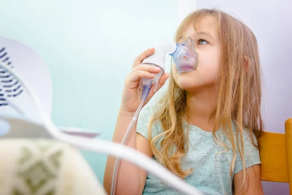 Porträtt av söt liten flicka med hjälp av en inhalator — Stockfoto