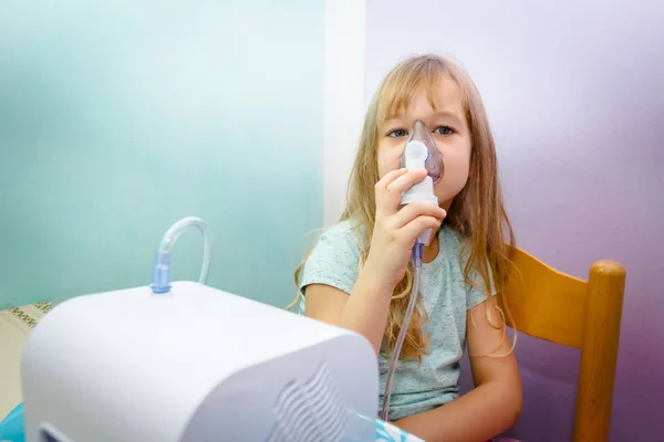 Porträtt av söt liten flicka med hjälp av en inhalator — Stockfoto