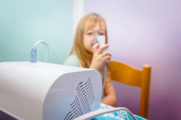 Portret van een lief klein meisje met een inhalator — Stockfoto