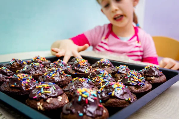 Retrato de dulce niño comiendo pastel, magdalenas decoradas —  Fotos de Stock