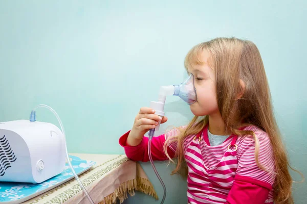 Porträtt av söt liten flicka med hjälp av en inhalator — Stockfoto