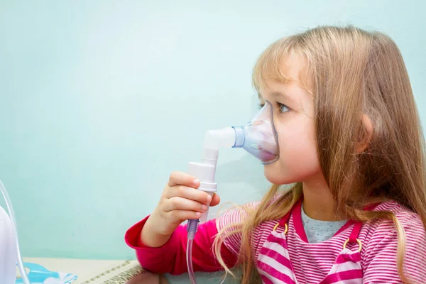 Portret van een lief klein meisje met een inhalator — Stockfoto