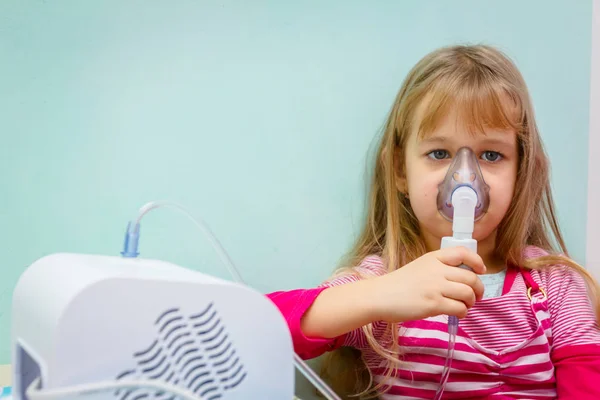 Porträtt av söt liten flicka med hjälp av en inhalator — Stockfoto