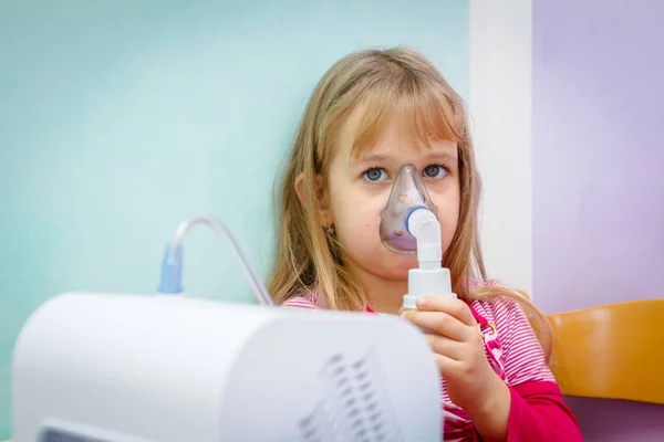 Porträtt av söt liten flicka med hjälp av en inhalator — Stockfoto