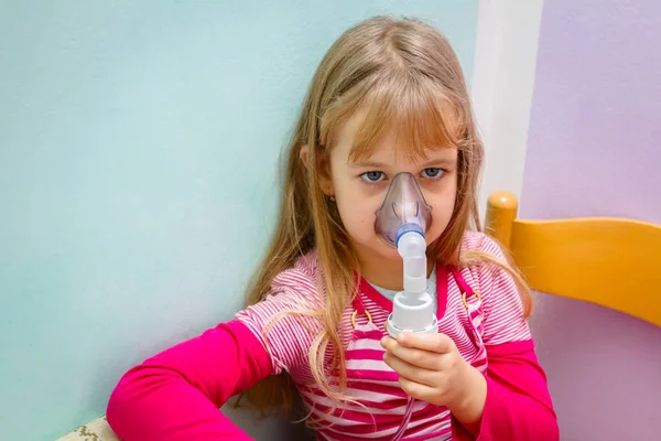 Porträtt av söt liten flicka med hjälp av en inhalator — Stockfoto