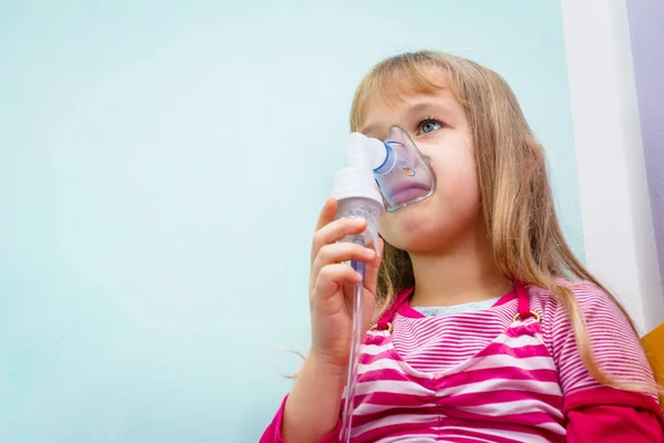 Porträtt av söt liten flicka med hjälp av en inhalator — Stockfoto