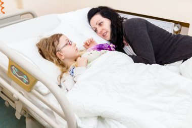 Annesi hasta çocuğunu hastane odasında ilgileniyor