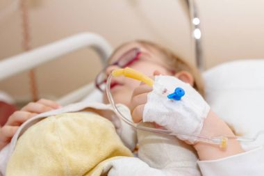 Okul öncesi çocuk, hasta üzerinde damla bir serum alıyor 