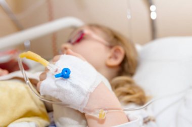 Okul öncesi çocuk, hasta üzerinde damla bir serum alıyor 