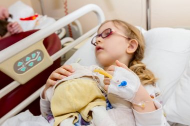 Okul öncesi çocuk, hasta üzerinde damla bir serum alıyor 