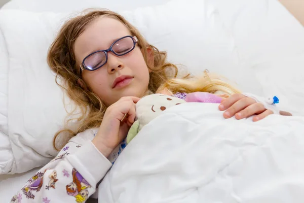 Niño preescolar yace enfermo en una cama en la sala de hospital — Foto de Stock